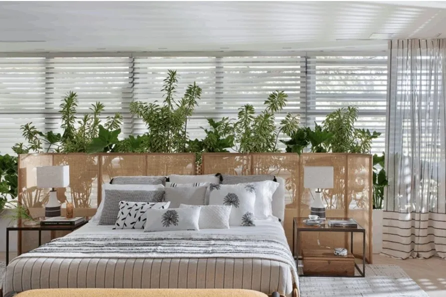 Quarto com cabeceira e prateleira cobertas de plantas, exemplo de ambiente biofílico apresentado na Casa Cor 2024.